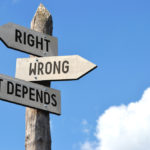 "Right, wrong, it depends" - wooden signpost, cloudy sky