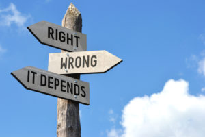 "Right, wrong, it depends" - wooden signpost, cloudy sky