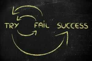 Blackboard showing the words "try", "fail" and "success", linked by arrows