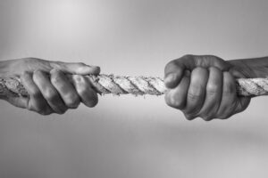 Hands pulling rope playing tug of war, people competitive, dispute, contest concept.